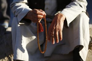 A Kurdish refugee man from the Syrian town of Kobani holds prayer beads in a camp in the southeastern town of Suruc